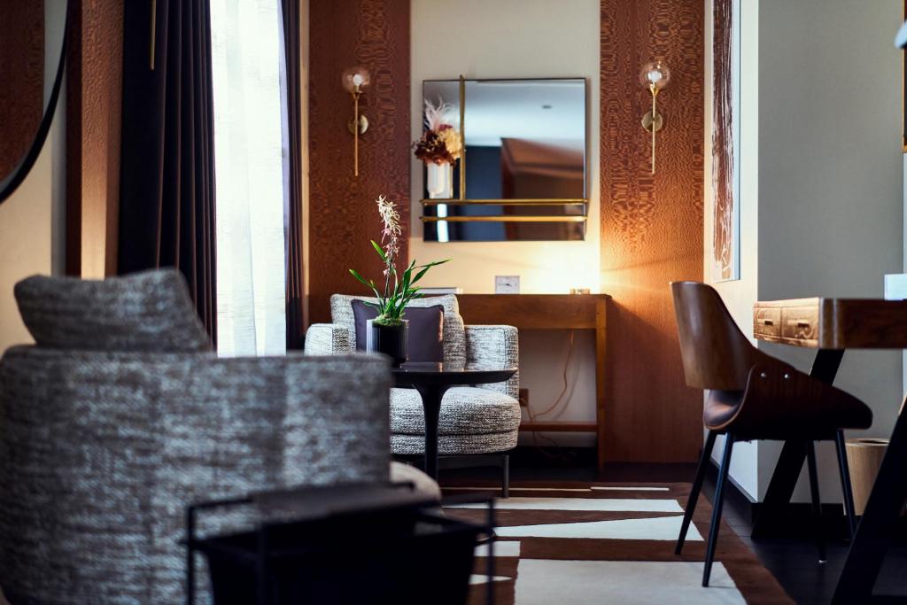 a living room with a table and chairs and a mirror at La Pyramide - Maison Henriroux in Vienne