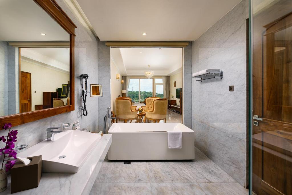 a bathroom with a large tub and a sink at Araliya Beach Resort & Spa Unawatuna- Where you meet the sea all year in Unawatuna