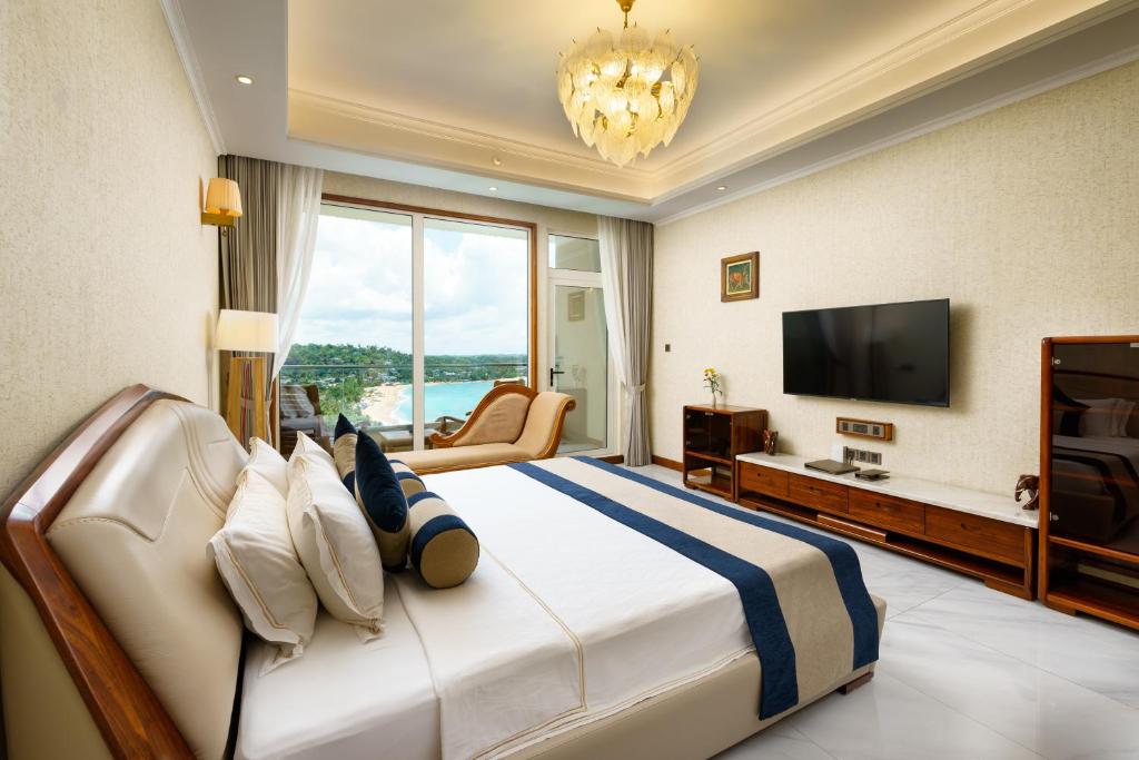 a bedroom with a large bed with a large window at Araliya Beach Resort & Spa Unawatuna- Where you meet the sea all year in Unawatuna