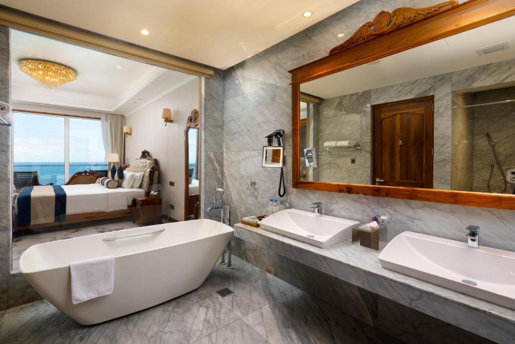 a bathroom with two sinks and a large mirror at Araliya Beach Resort & Spa Unawatuna- Where you meet the sea all year in Unawatuna