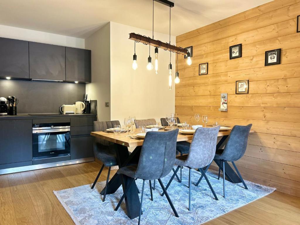 une cuisine et une salle à manger avec une table et des chaises dans l'établissement Bel appartement neuf aux Gets, proche des pistes, avec terrasse et parking sécurisé - FR-1-623-335, aux Gets