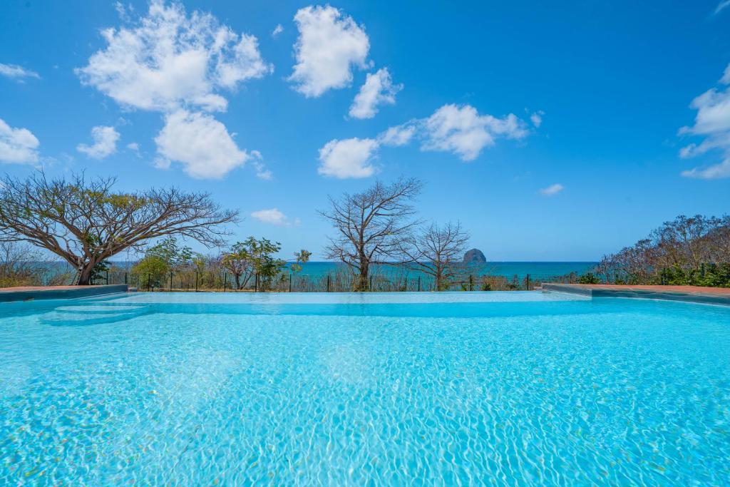 A piscina localizada em Villa Les Caramboles : Piscine vue mer, acc&egrave;s direct superbe plage sable ou nos arredores