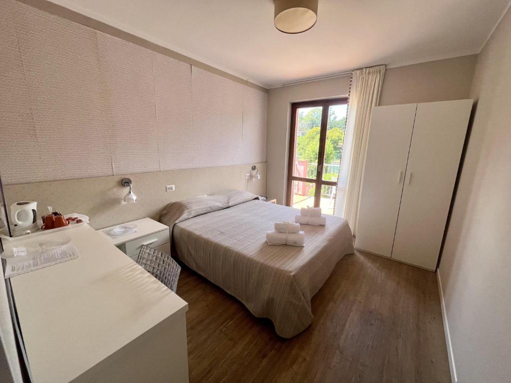 mała sypialnia z łóżkiem i oknem w obiekcie Hotel Villa Rosa w mieście Porto Azzurro