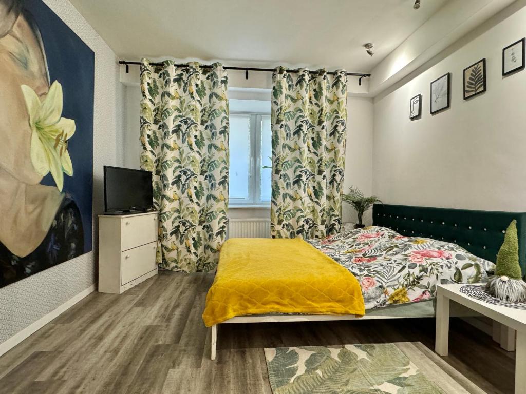 a bedroom with a bed and a tv and curtains at Apartment Warsaw Powiśle in Warsaw