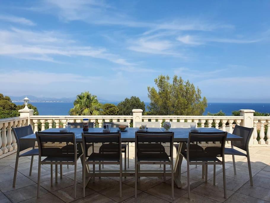 Une table à manger bleue et des chaises sont disponibles sur la terrasse. dans l'établissement VILLA 4 Étoiles , La Caravelle , Mer à 400 metres , été du Dimanche au Dimanche, à Saint-Peïre-sur-Mer