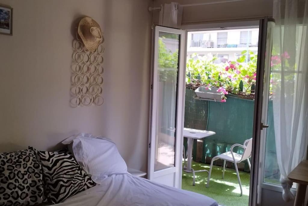 une chambre avec un lit et une porte coulissante en verre dans l'établissement Charmant F1 terrasse ombragée, au Cannet