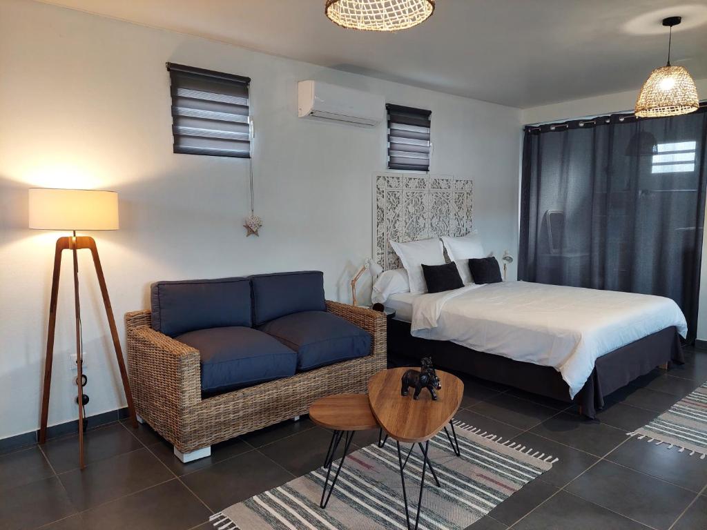 pokój hotelowy z łóżkiem i kanapą w obiekcie "Koko Lodge" Lodge paisible avec terrasse, jardin et piscine w mieście Rémiré