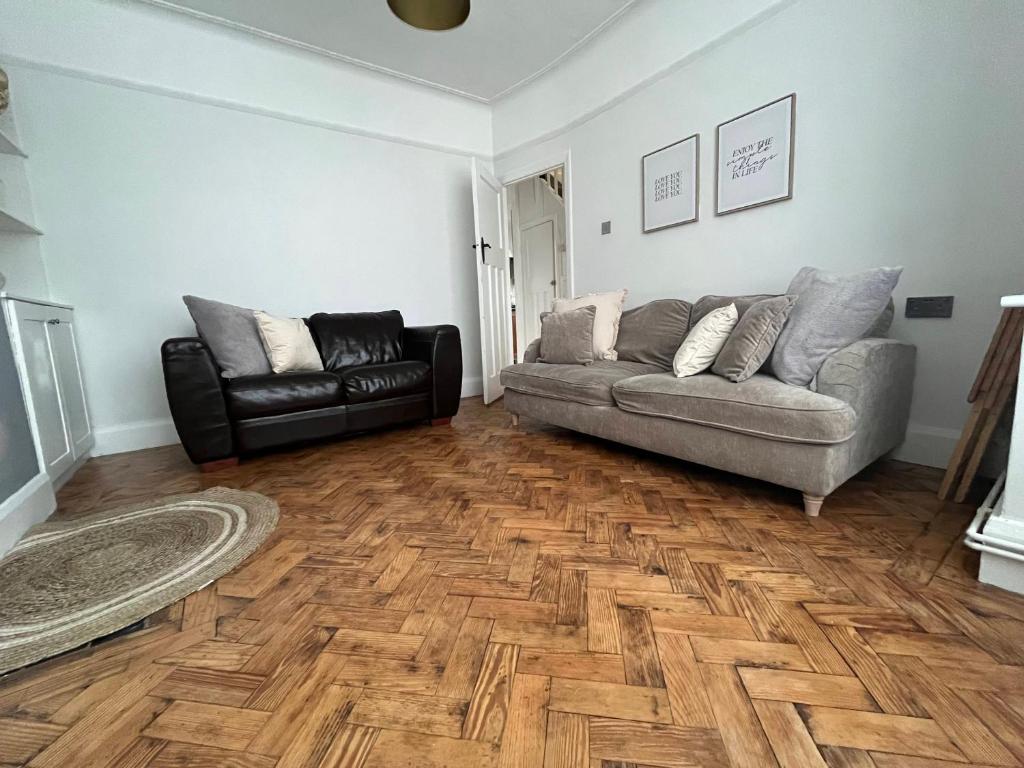 a living room with a couch and a chair at Cosy 3-Bedroom House 15mins to Olympic Village in Romford