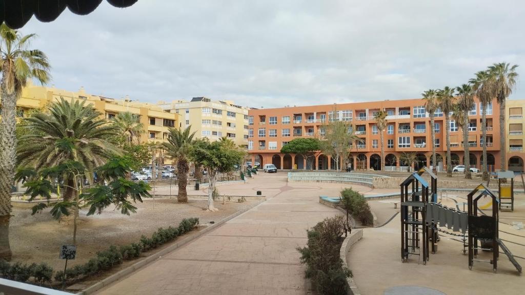 un parque con palmeras frente a un edificio en Almichara, en El Médano