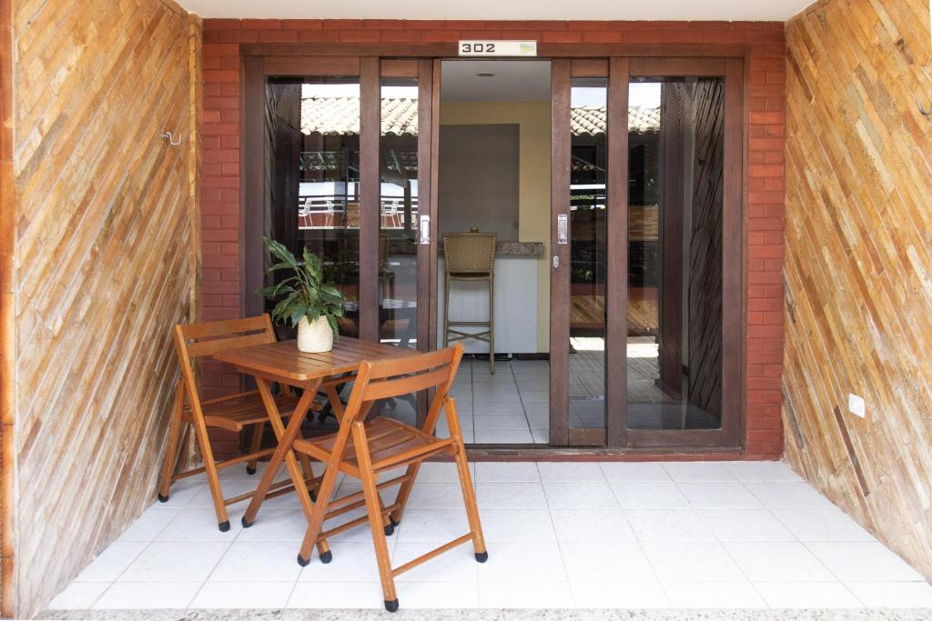 a patio with a table and two chairs and a plant at Pipas Ocean by Pipa Centro in Pipa