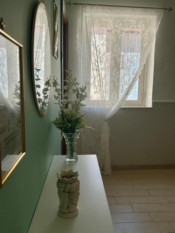 a vase on a table in a room with a window at La Finestrella in Giardina Gallotti