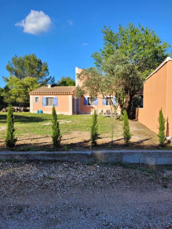 une maison avec des arbres dans la cour avant dans l'établissement Location saisonnière villa Lauris, à Lauris