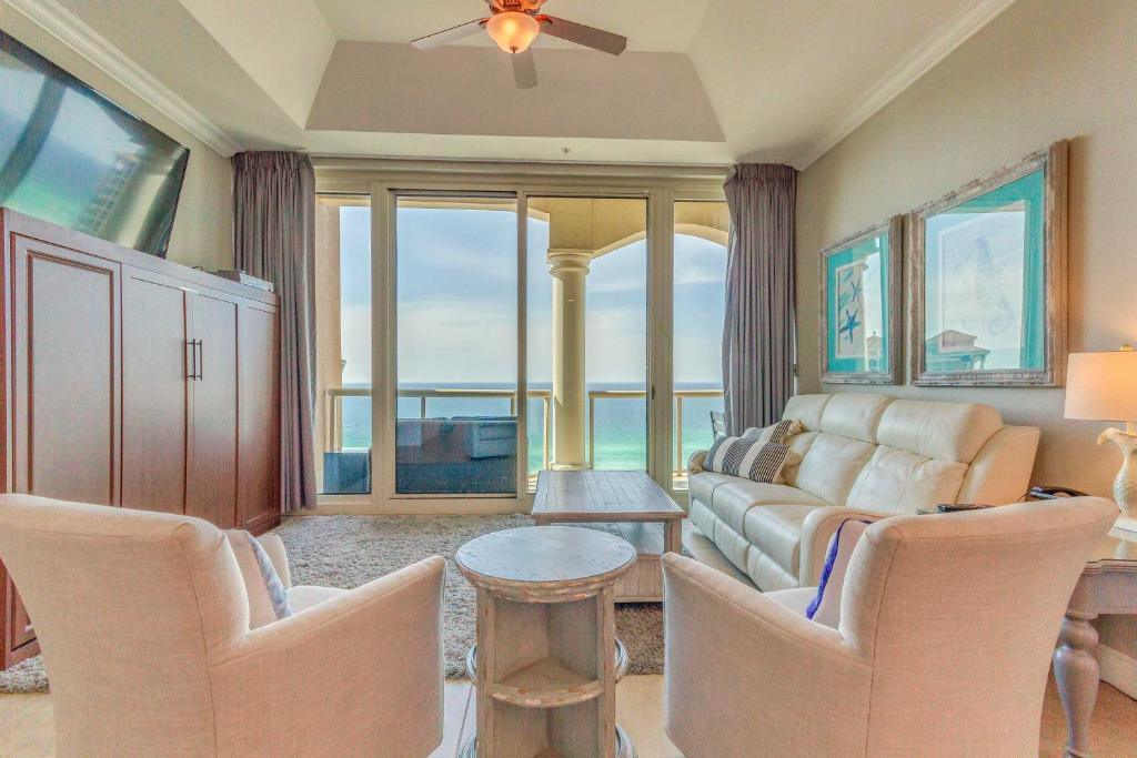 un soggiorno con divano, tavolo e sedie di Pensacola Beach Penthouse with View and Pool Access! a Pensacola Beach