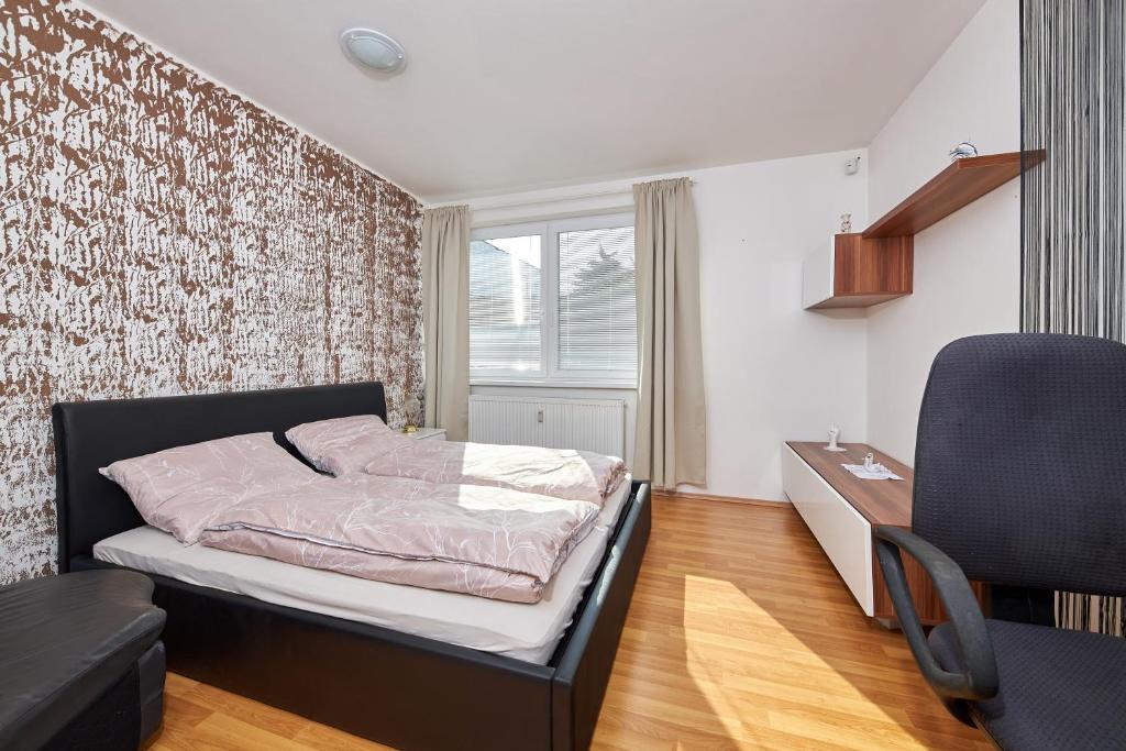 a bedroom with a bed and a desk and a chair at Cutie apartment in Bratislava