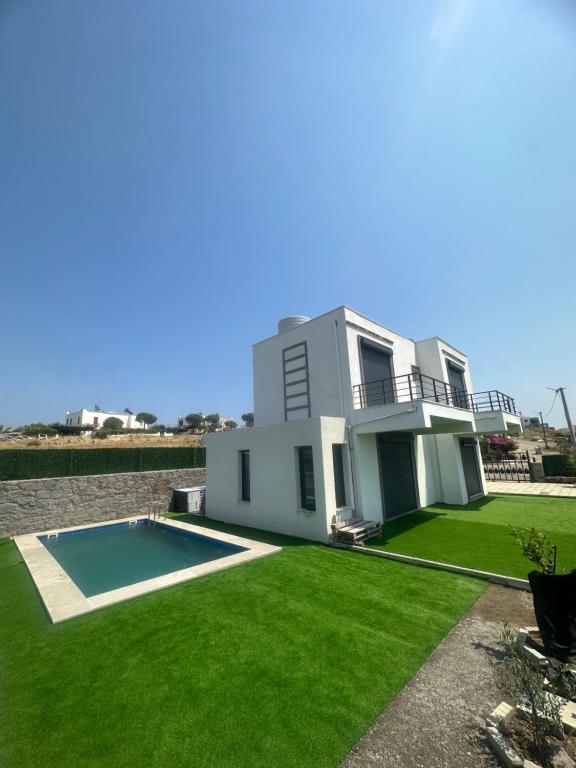 a house with a swimming pool in the yard at Villa Helios in Gürece