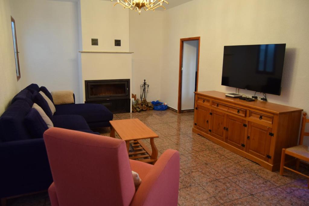 a living room with a couch and a flat screen tv at Casa Rural O Noso Lar in Raspay