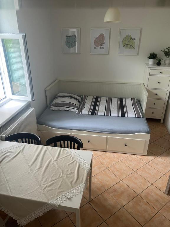 een slaapkamer met een bed en een tafel en stoelen bij Apartmán Papoušek in Znojmo