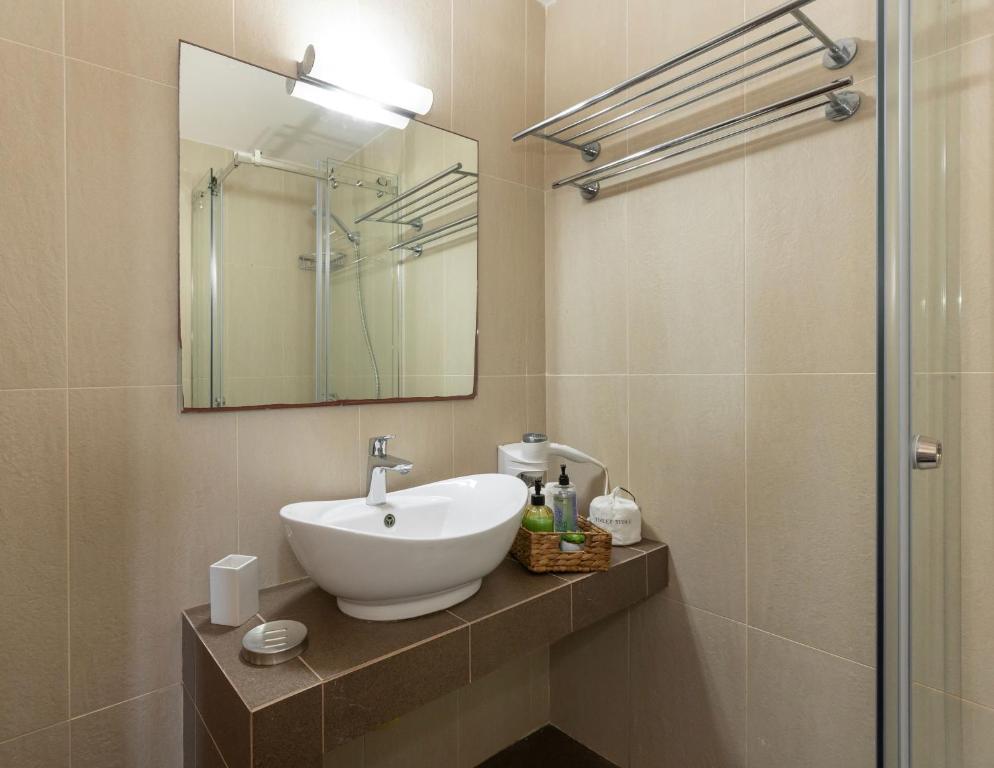 a bathroom with a sink and a mirror at Oinoni's Home - XANTHIPI apartment in Souvala