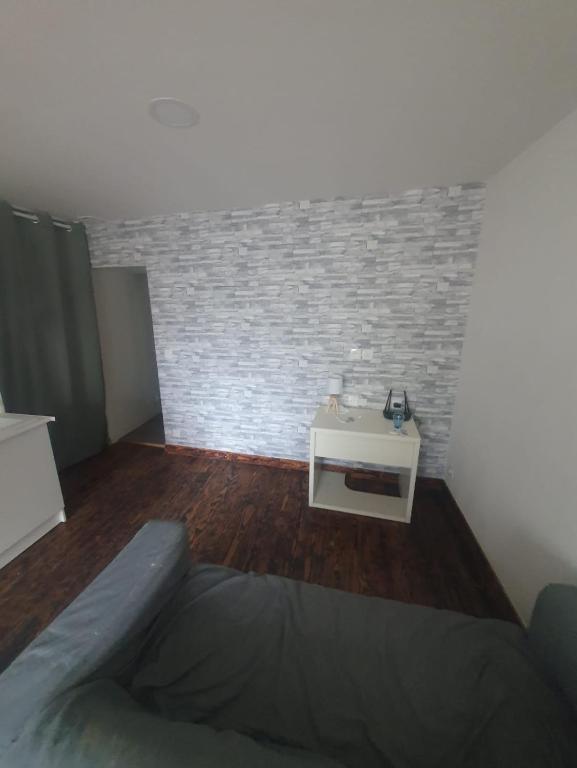 Cette chambre dispose d'une table et d'un mur en briques. dans l'établissement Centre, à Morlaix