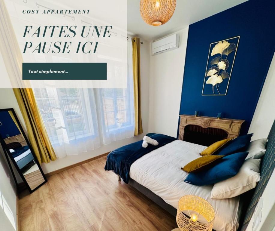 um quarto com uma cama com uma parede azul em Chaleureux T2 proche gare em Bourgoin