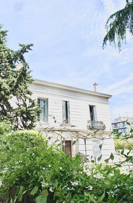 une maison blanche avec des arbres devant dans l'établissement Appartement Cosy, au Cannet
