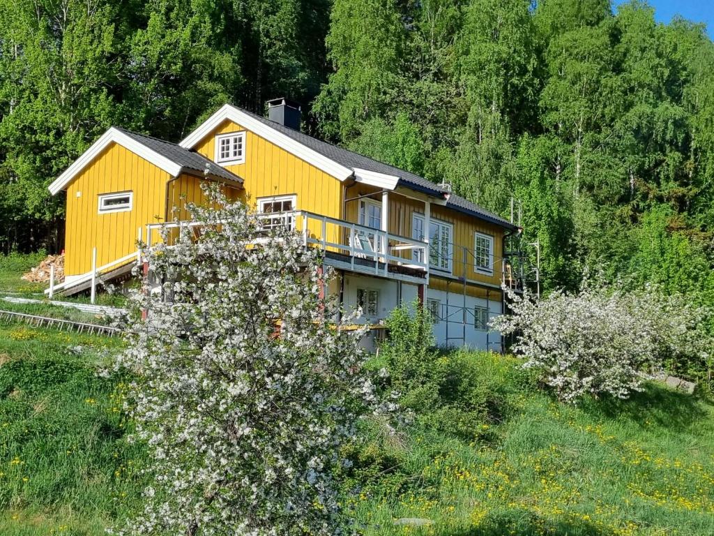 uma casa amarela no lado de uma colina em Solhaug em Torpo