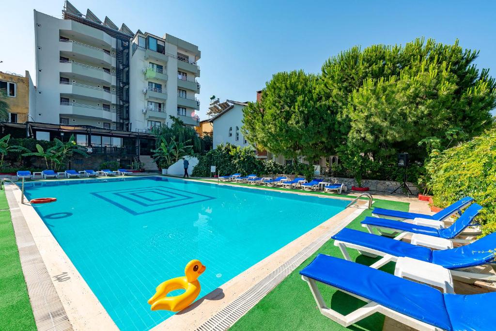 a swimming pool with chairs and a yellow rubber duck in it at ALİBABAM APART OTEL in Kuşadası