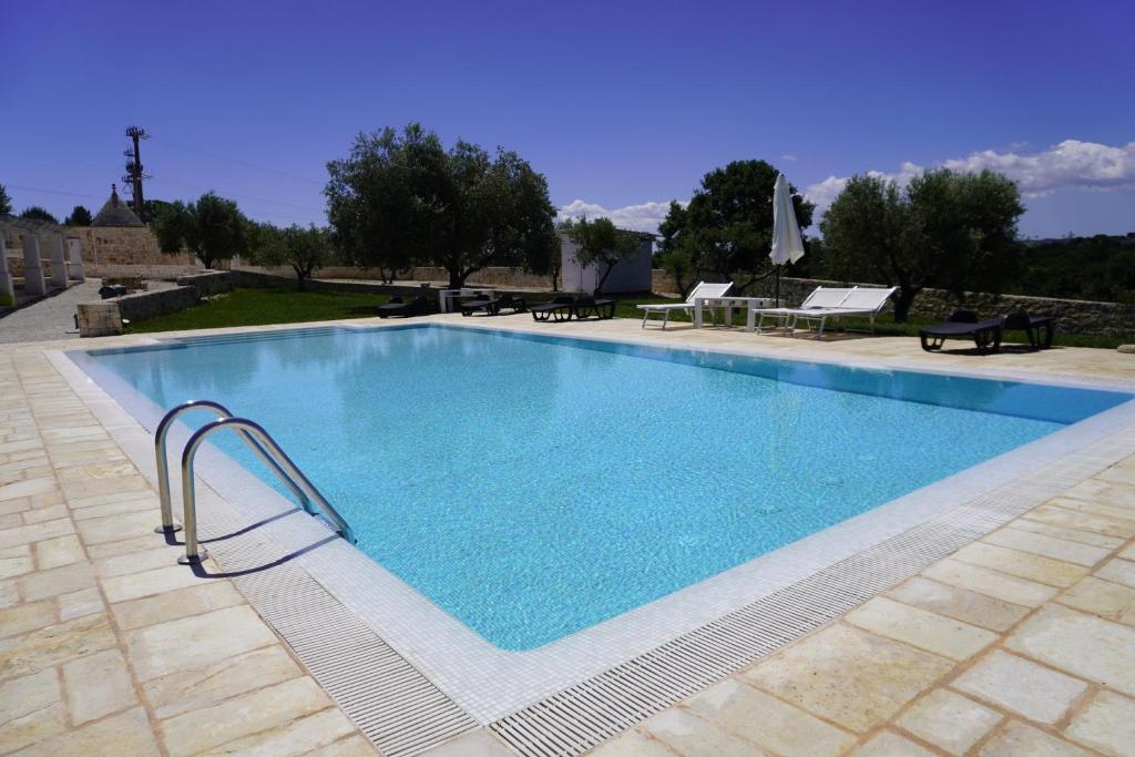 una grande piscina con acqua blu di Trullo Amico a Cisternino