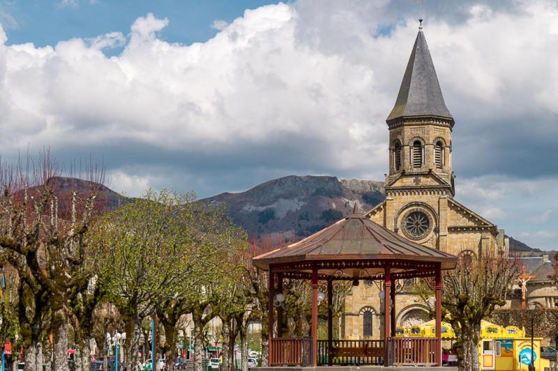 una chiesa con una torre dell'orologio e un gazebo di Appt lumineux, Thermes et Montagne a La Bourboule