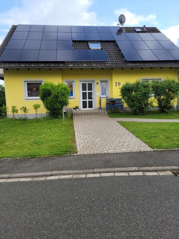 a yellow house with solar panels on the roof at Gelbes Haus Heldritt in Bad Rodach