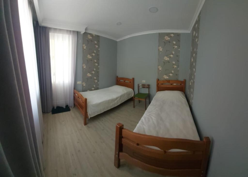 a bedroom with two beds and a window at M7 House in Gorists'ikhe