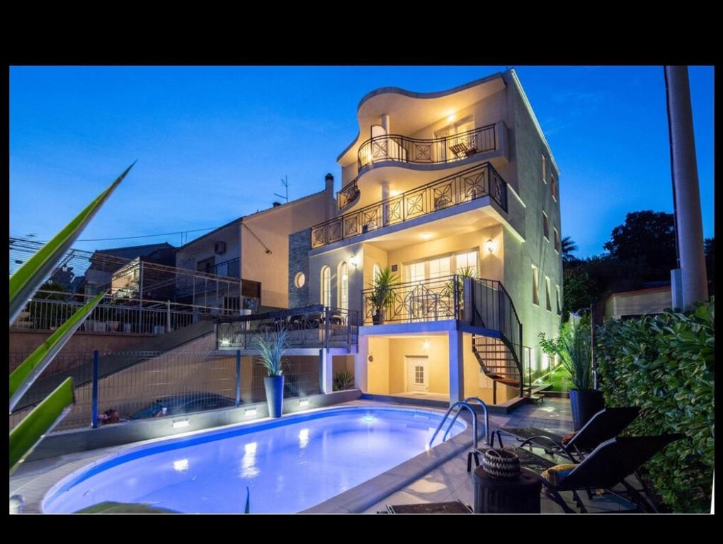 a large building with a swimming pool in front of it at Luxury Apartments with Private Pool and Sauna or with jacuzzi near Split , Sea View in Podstrana