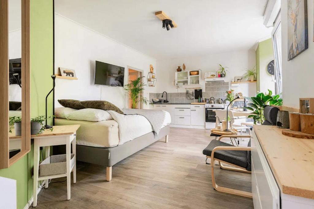 een slaapkamer met een bed en een keuken bij Cozy House - fietsverhuur, eigen keuken en badkamer in Nijmegen