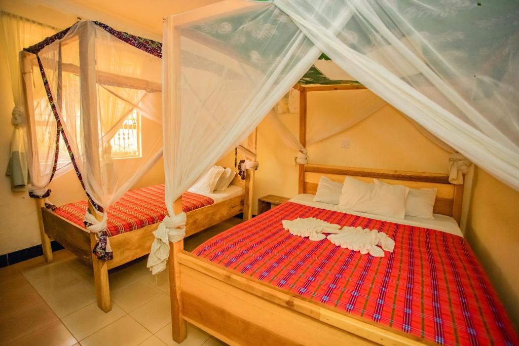 a bedroom with two beds with mosquito nets at Kilimanjaro Vines Retreat Hotel Mdawi in Moshi