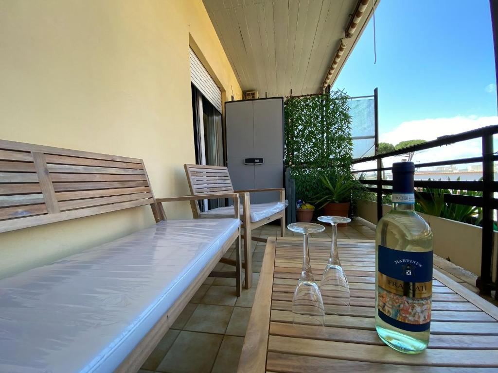 Una botella de vino en la parte superior de un balcón en Coastal House - Spiaggia e Piscina a dieci passi, en Santa Marinella