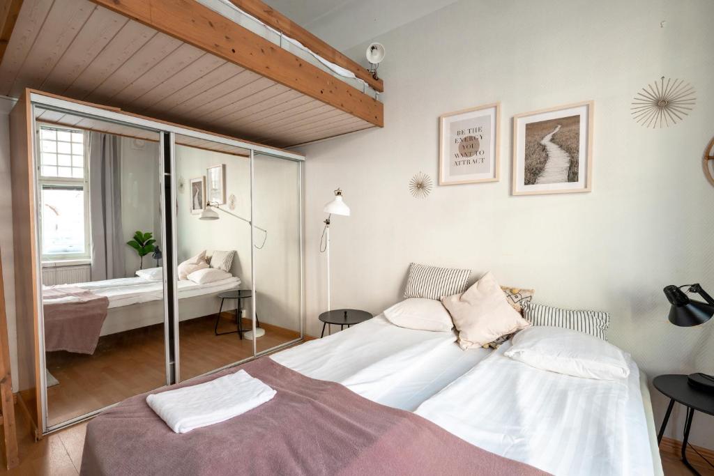 Schlafzimmer mit einem Bett und einem Spiegel in der Unterkunft 2ndhomes Kamppi Apartments 1 in Helsinki