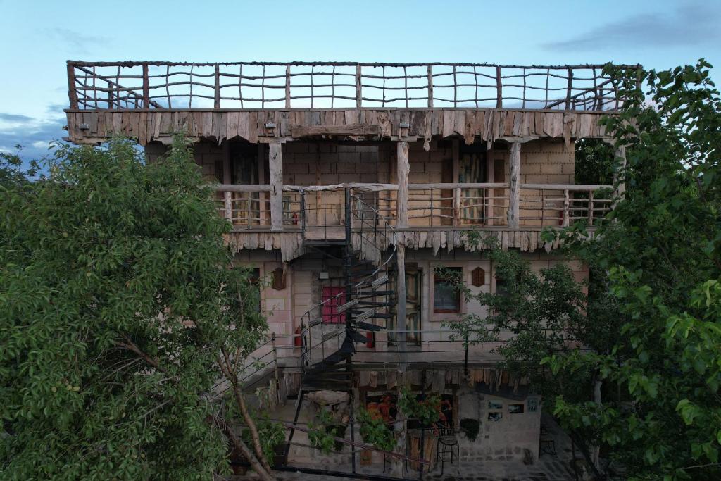 un edificio antiguo con un balcón en el lateral. en Philosophy Hotel en Uchisar