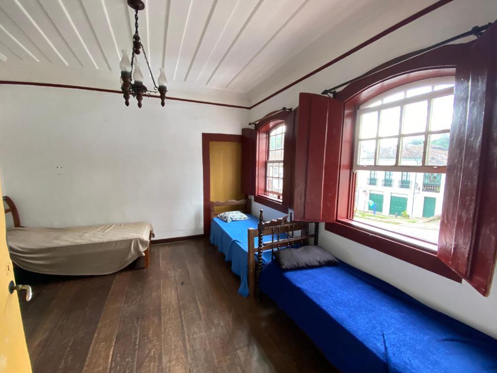 a room with two beds and a window at República Birinaite in Ouro Preto