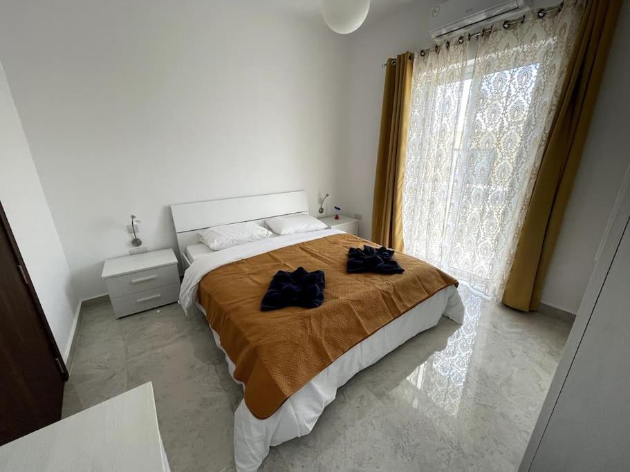una camera da letto con un grande letto con due sacchi neri sopra di Apartment, Few Steps from Ghadira Bay a Mellieħa