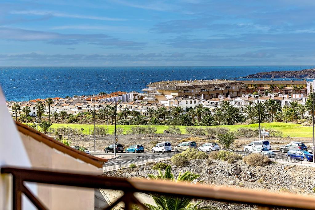 een uitzicht op een stad met auto's geparkeerd op een straat bij Ocean View Apartment in Albatros Golf del Sur in San Miguel de Abona