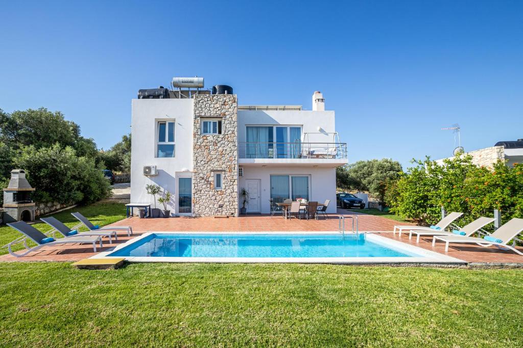 una villa con piscina di fronte a una casa di DIMITRA apartment with private pool and sea view -the ground floor of a two storey building a Daratso