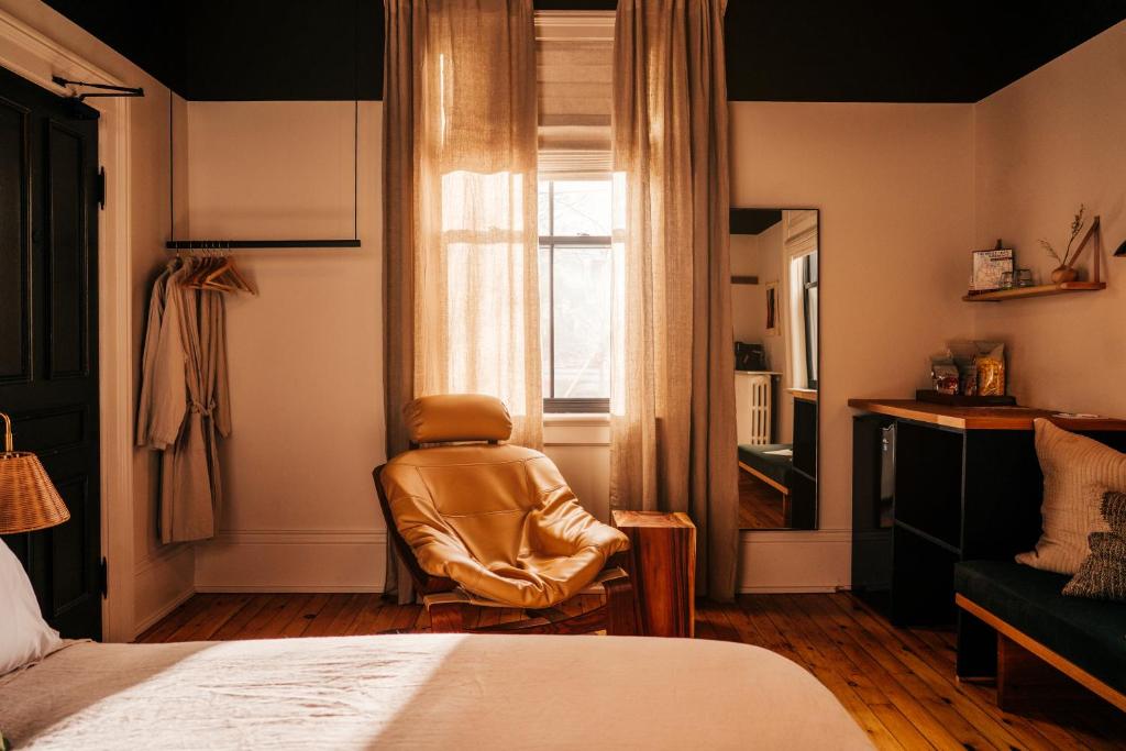 a room with a chair and a bed and a window at Somewhere Inn Collingwood in Collingwood