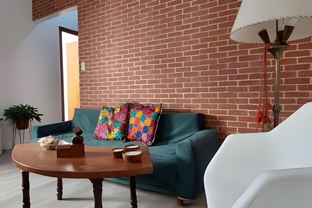 uma sala de estar com um sofá verde e uma mesa em Pasión de Tango en el corazón de Almagro em Buenos Aires