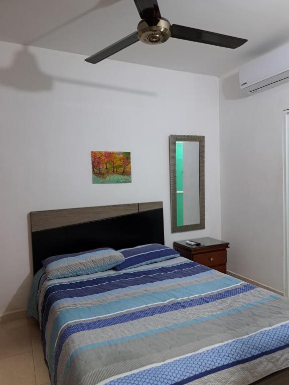 Un dormitorio con una cama y un ventilador de techo. en Arriendo habitaciones amobladas con aire acondicionado, en Montería