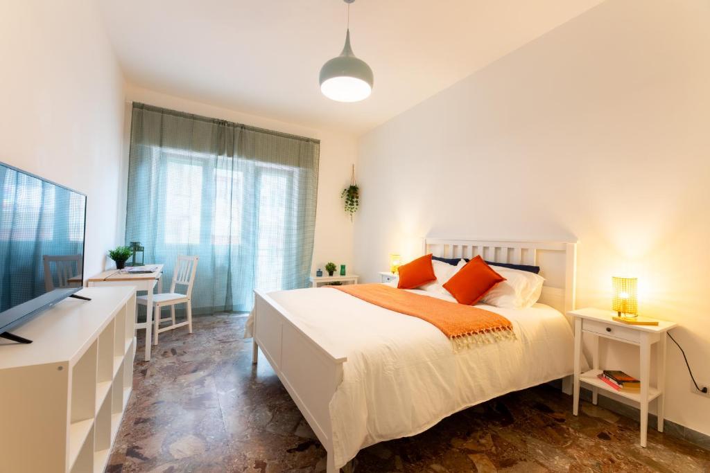 Un dormitorio con una cama, un escritorio y un televisor. en Flower Apartment, en Roma
