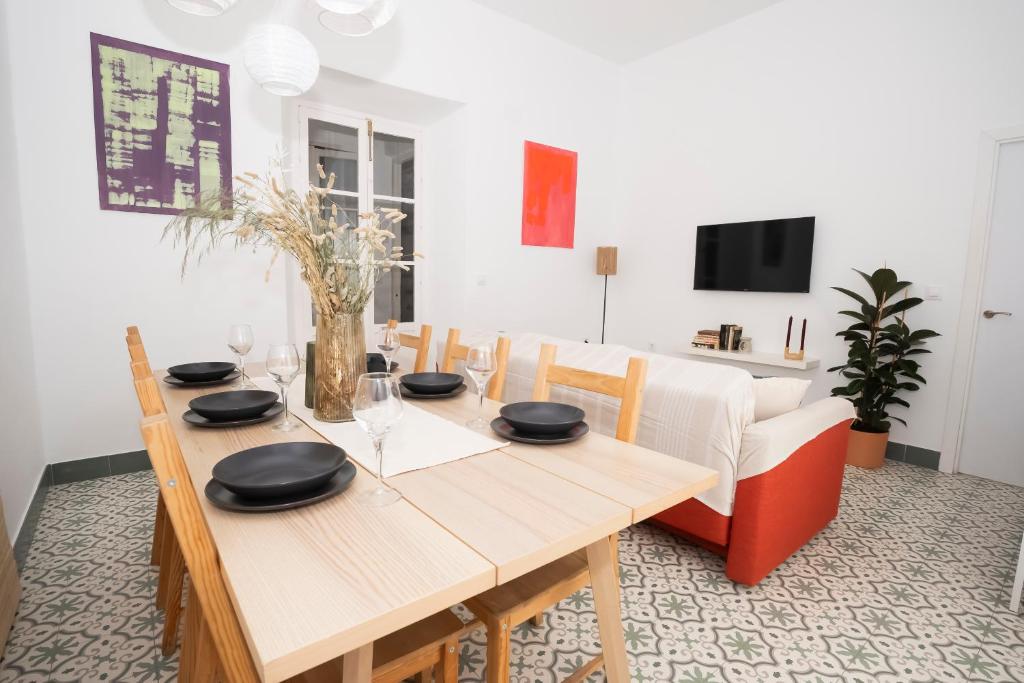 comedor con mesa de madera y sofá en California Apartament Dos de Mayo, en Sevilla