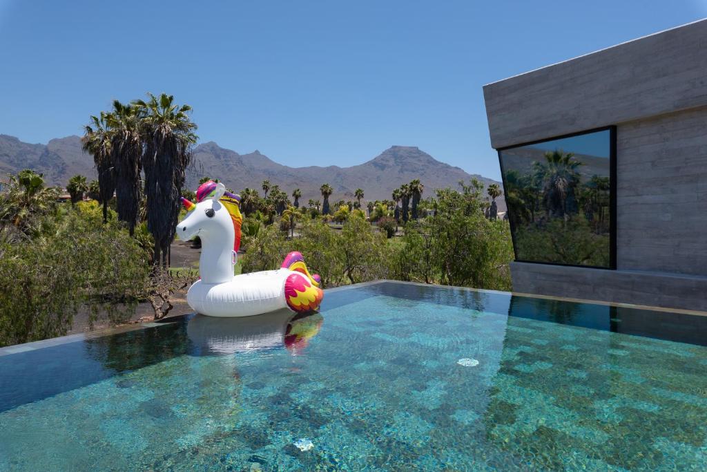 a pool with a unicorn inflatable toy in the water at KARAT Villa Calypso Costa Adeje in Adeje