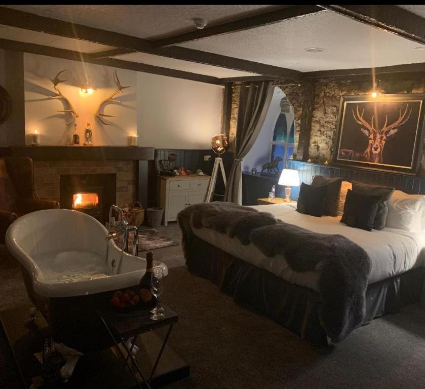sypialnia z dużym łóżkiem i wanną w obiekcie OYO Auldgirth Inn w mieście Auldgirth