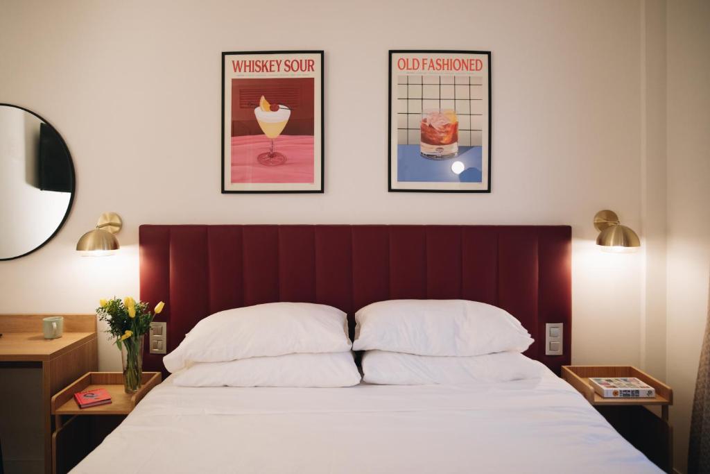 um quarto com uma cama e dois cartazes na parede em H La Paloma Boutique em Barcelona