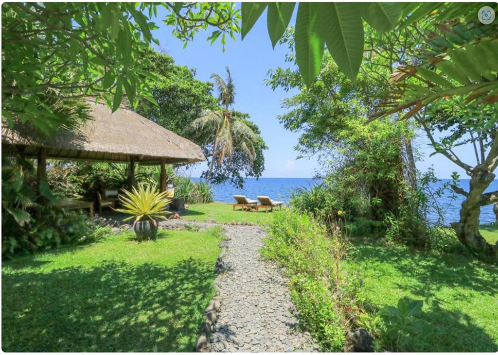 a path leading to a resort with a view of the ocean at Palm Beach Villas Bali in Singaraja